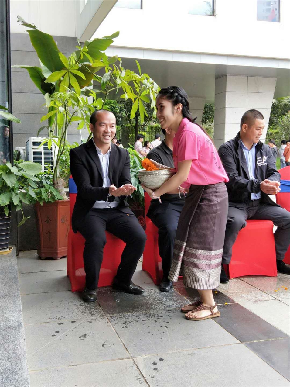 老撾駐廣西留學生代表將浸有花瓣的香水灑客人的手上，表示對嘉賓的美好祝福（圖一）