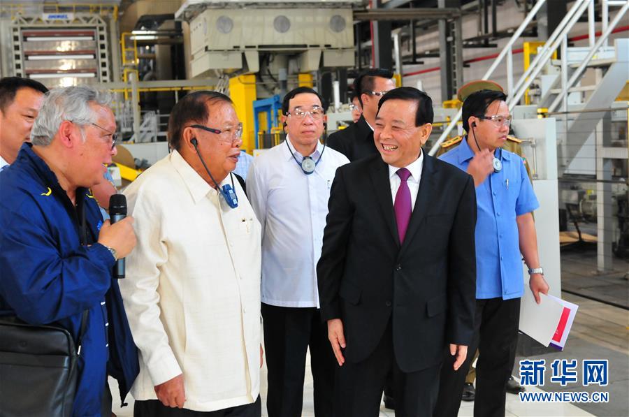 3月10日，在老撾沙灣拿吉省車邦縣，老撾人民革命黨中央總書記、國家主席本揚(yáng)（左二）在山東太陽紙業(yè)股份有限公司董事長李洪信（右二）的陪同下視察公司。 新華社記者章建華攝